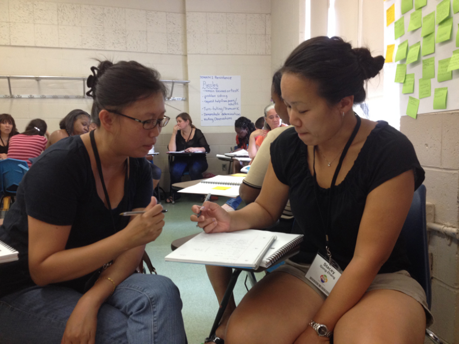 Asian mentor and intern reviewing lesson plans.